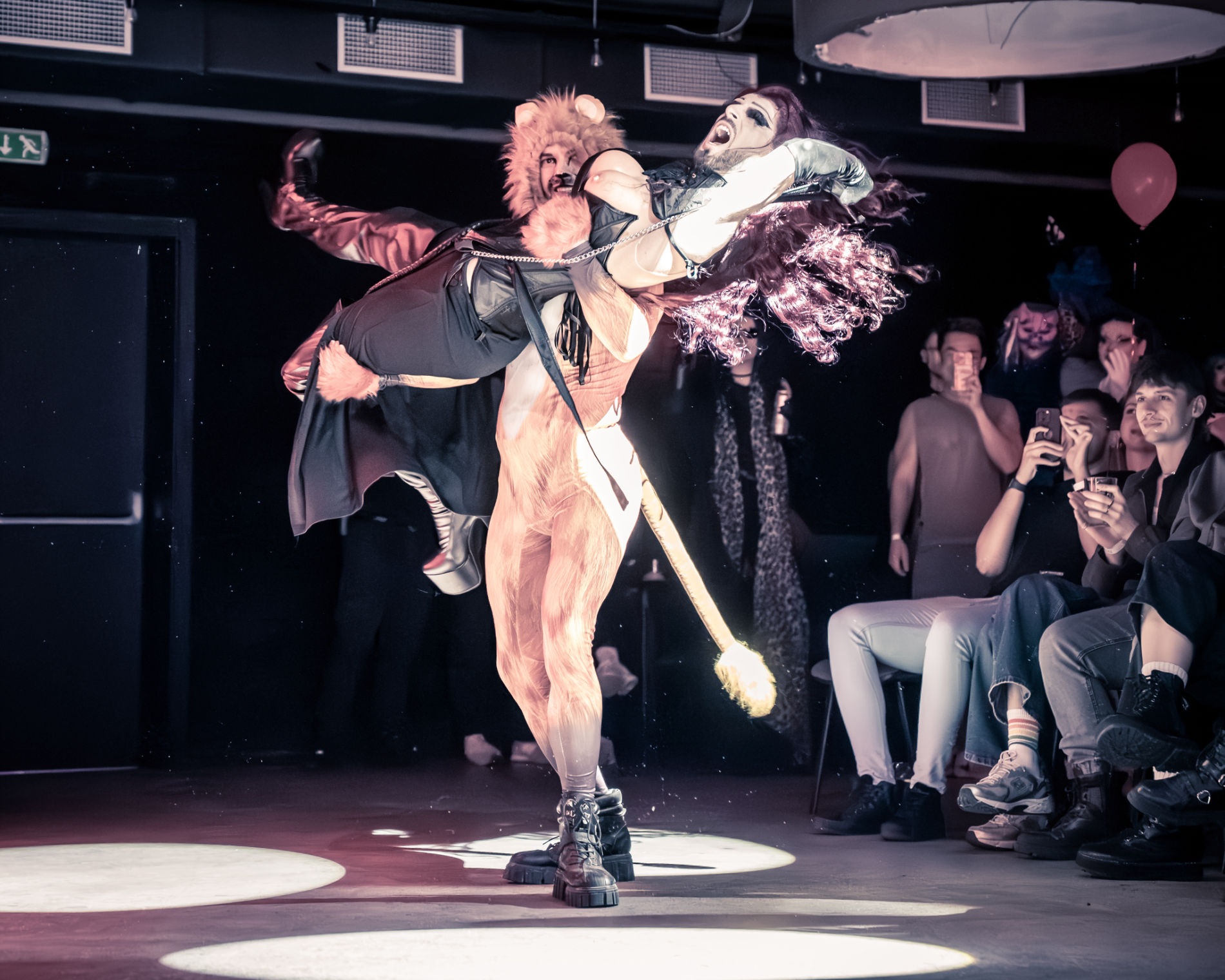 Drag performer posing under colorful lights at a DRAGRIFT show