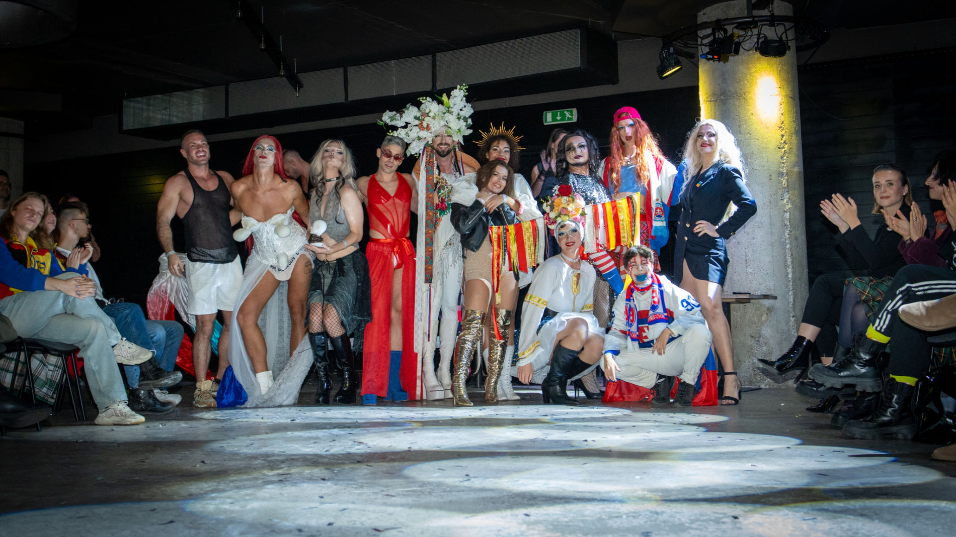 Performer strutting across the DRAGRIFT stage in dramatic lighting